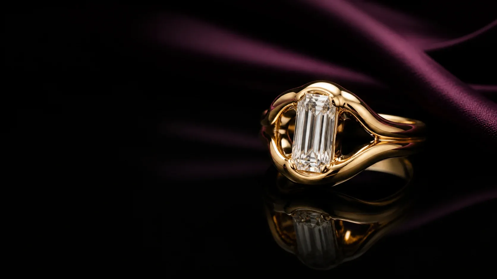 Sculptural gold ring with an emerald-cut diamond on black lacquer and aubergine silk