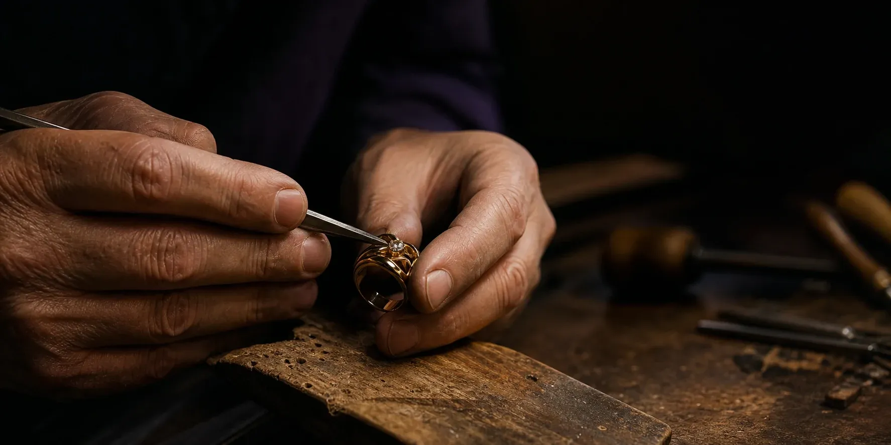 Master jeweler setting a diamond into a sculptural gold ring by hand